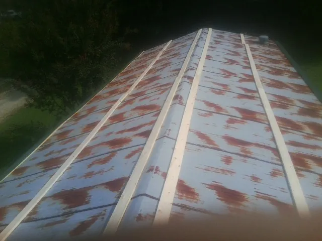 Rusted metal roof panels with new wood purlins before replacement — Storm Damage Roof Repair in Linville by Roofing Brothers