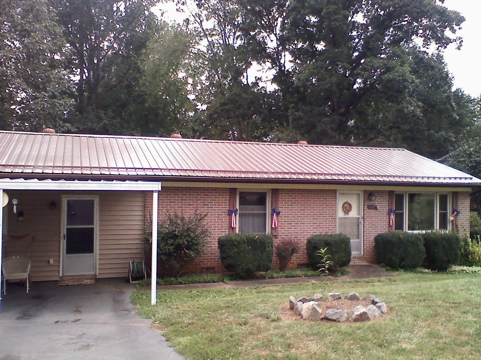 Bronze metal roof and carport on a brick ranch home — Roof Repair work by our crew in Linville